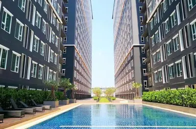 a swimming pool in the middle of two tall buildings at Comfy1BR at Bangson byBB in Bangkok