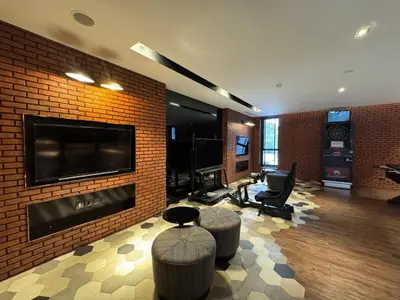 a living room with a brick wall with a tv and chairs at River Cando Perfect for relaxing in Ban Sai Ma