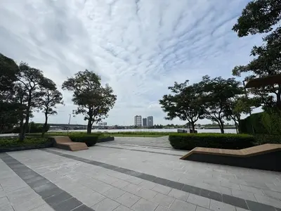 a park with benches and trees under a cloudy sky at River Cando Perfect for relaxing in Ban Sai Ma