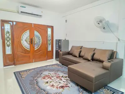 a living room with a couch and a door at Nan Square II in Bangkok