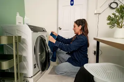 a woman putting clothes into a washing machine at Blue House 191 Hometel in Chinatown