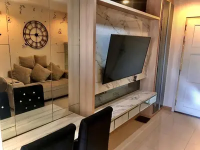 a living room with a couch and a large television at Supalai Wellington 2 in Ban Na Song