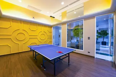a ping pong table in a room with a yellow wall at Supalai Wellington 2 in Ban Na Song