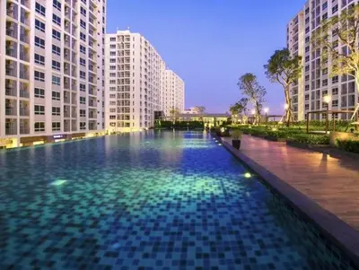a large swimming pool in a city with tall buildings at Supalai Wellington 2 in Ban Na Song