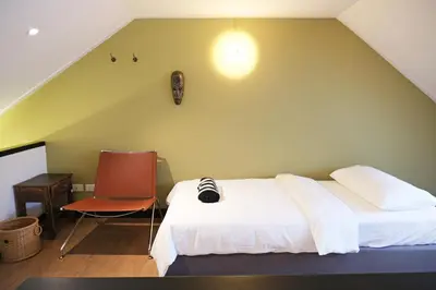a bedroom with a white bed and a chair at Stylist Siamese Design House Steps To Chinatown - Self Check In in Bangkok