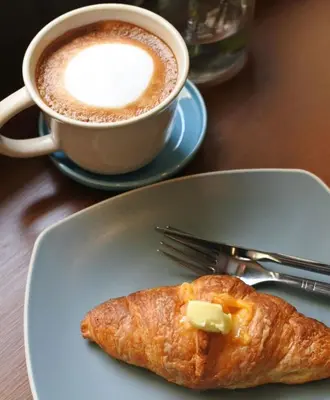 a plate with a pastry and a cup of coffee at Lemoncurd Bread and Coffee in Bangkok