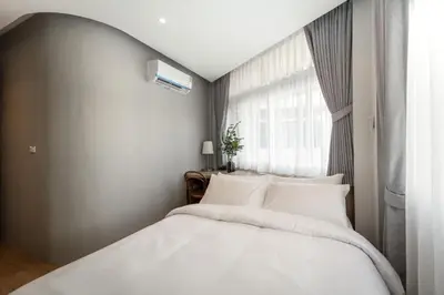 a bedroom with a white bed and a window at Lemoncurd Bread and Coffee in Bangkok