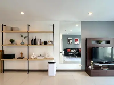 a living room with a television and a couch at Stylish 2BR City View - BTS St.Louis - Ultra Fast Wifi in Bangkok
