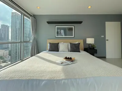 a bedroom with a large bed with a large window at Stylish 2BR City View - BTS St.Louis - Ultra Fast Wifi in Bangkok
