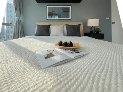 a bed with a tray with a book on it at Stylish 2BR City View - BTS St.Louis - Ultra Fast Wifi in Bangkok