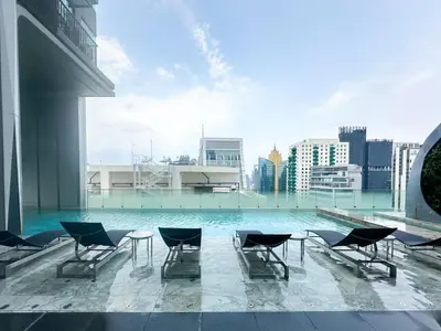 a pool on the roof of a building with chairs at Urban Chic Living - 1BR - Ultra Fast WiFi - BTS Asoke in Bangkok