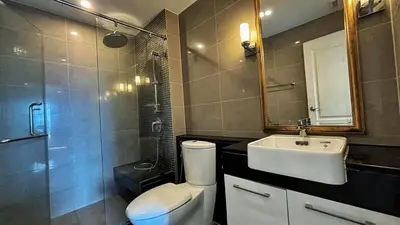a bathroom with a toilet and a sink and a shower at คอนโดศุภาลัยเวลลิงตัน2 in Bangkok
