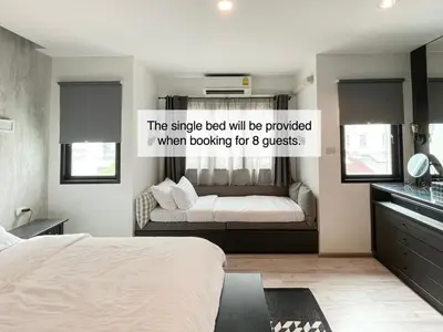 a bedroom with a bed and a couch in it at Vélin - Samsen in Bangkok