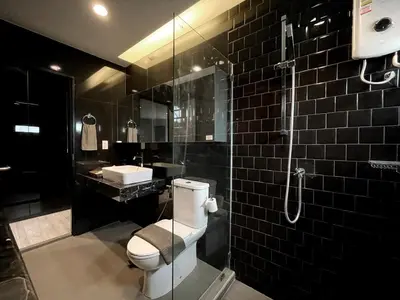 a bathroom with a toilet and a glass shower at Vélin - Samsen in Bangkok