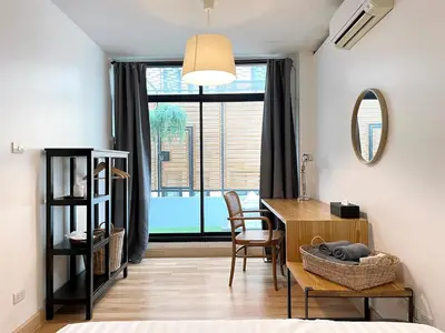 a dining room with a table and a large window at Vélin - Samsen in Bangkok