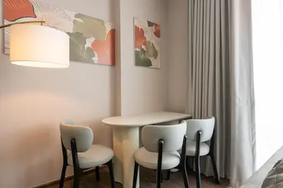 a room with a table and four chairs at The Rich Grand Residence Sukhumvit in Bangkok