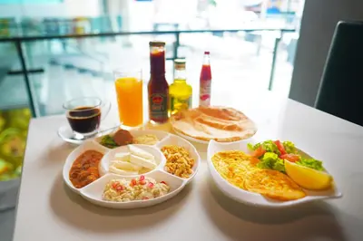 a table with a tray of breakfast foods and drinks at The Rich Grand Residence Sukhumvit in Bangkok