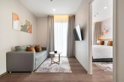 a living room with a couch and a bed at The Rich Grand Residence Sukhumvit in Bangkok