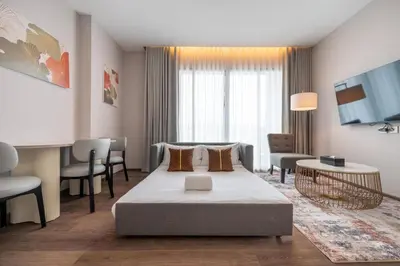 a hotel room with a bed and a living room at The Rich Grand Residence Sukhumvit in Bangkok