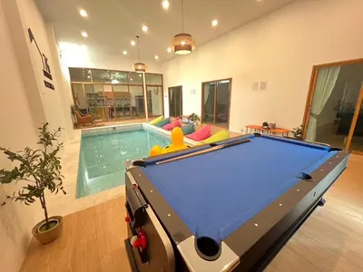 a pool table in a room with a swimming pool at นวมินทร์ 76 พูลวิลล่า - Nawamin 76 Poolwilla in Ban Baen Phichit