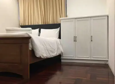 a bedroom with a bed and white cabinets at Trinity City View 3BR Spacious Family Silom in Bangkok
