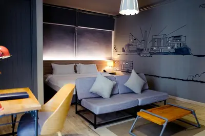 a bedroom with a bed and a blue couch at THA City Loft by TH District in Bangkok
