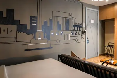 a wall with a mural of a train on it at THA City Loft by TH District in Bangkok