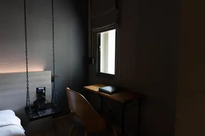a room with a desk and a bed and a window at THA City Loft by TH District in Bangkok
