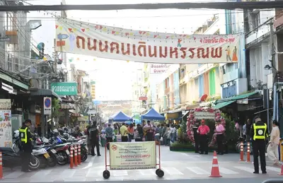 a crowd of people walking down a busy city street at xxGO INN The Giant Swing - เสาชิงช้า in Bangkok