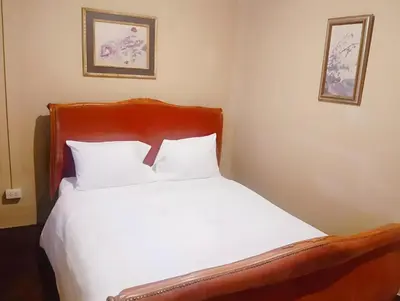 a bed with white sheets and two pictures on the wall at xx Rest Inn Yaowarat Bangkok - เรสอินน์ เยาวราช in Samphanthawong