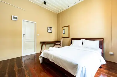 a bedroom with a large white bed and a table at xx Rest Inn Yaowarat Bangkok - เรสอินน์ เยาวราช in Samphanthawong