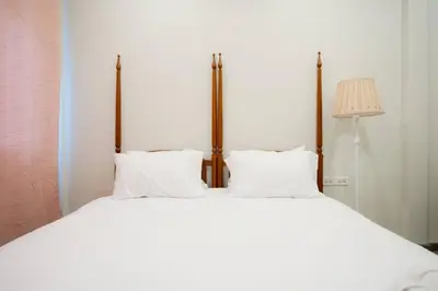 a large white bed with two pillows and a lamp at XX Hidden Dragon Yaowarat Road in Bangkok