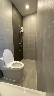 a bathroom with a toilet and a phone on the wall at XX Hidden Dragon Yaowarat Road in Bangkok