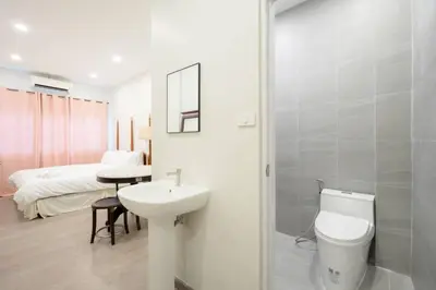 a bathroom with a sink and a toilet and a bed at XX Hidden Dragon Yaowarat Road in Bangkok