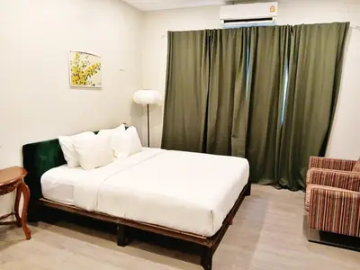 a bedroom with a white bed and a green curtain at XX Hidden Dragon Yaowarat Road in Bangkok