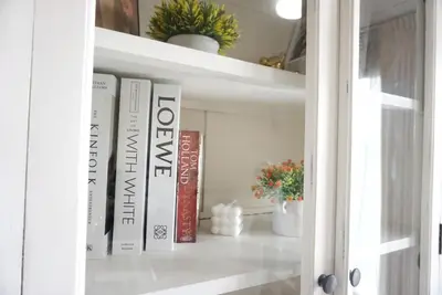 a book shelf with books and plants on it at Central next to Shopping 1 Bedroom Condo - 2 Min to BTS Asok and Terminal 21 in Bangkok