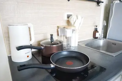 a kitchen counter with a frying pan on a stove at Central next to Shopping 1 Bedroom Condo - 2 Min to BTS Asok and Terminal 21 in Bangkok