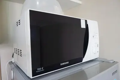 a video game system sitting on top of a shelf at Central next to Shopping 1 Bedroom Condo - 2 Min to BTS Asok and Terminal 21 in Bangkok