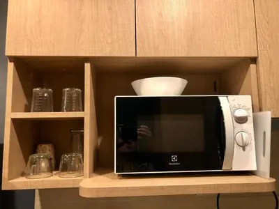 a microwave on a shelf in a kitchen at 1 Bedroom at Q Chidlom in Bangkok
