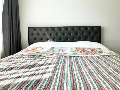 a bed with a colorful quilt on top of it at Resort Style room Ellio Monthly Available in Bangkok
