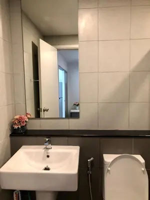 a bathroom with a sink and a toilet and a mirror at Resort Style room Ellio Monthly Available in Bangkok