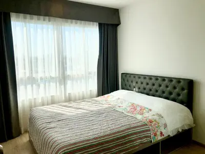 a bedroom with a bed with a large window at Resort Style room Ellio Monthly Available in Bangkok