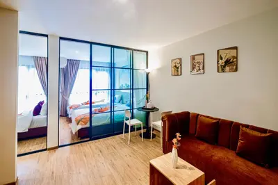 a living room with a couch and a bedroom at Metro Hotel Phahonyothin 35 in Bangkok