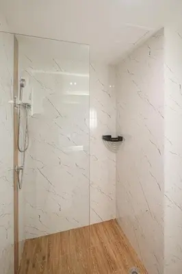 a shower with a glass door in a bathroom at Metro Hotel Phahonyothin 35 in Bangkok