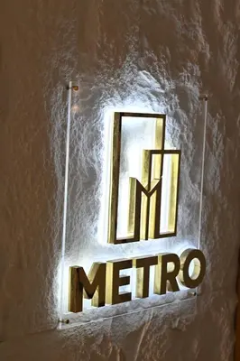 a sign on a wall with a metro sign on it at Metro Hotel Phahonyothin 35 in Bangkok