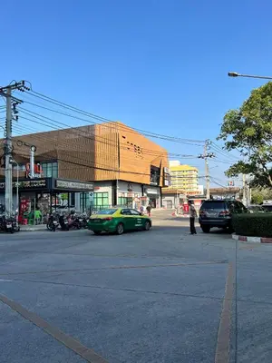 a parking lot with a green car in front of a building at Great facilities n River view n Local in Ban Sai Ma