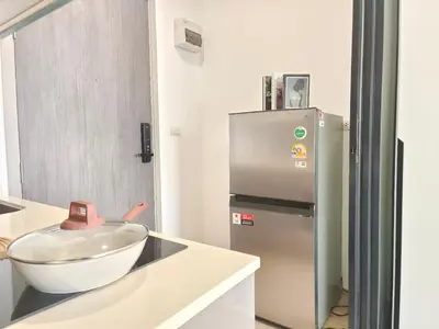 a kitchen with a bowl on a counter next to a refrigerator at The Rich Rama 9 Luxury Condos in Sathani Ban Hua Mak