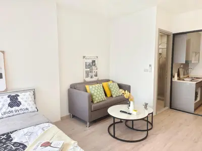 a living room with a couch and a table at The Rich Rama 9 Luxury Condos in Sathani Ban Hua Mak