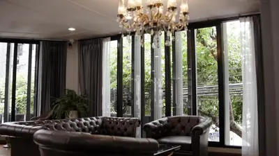 a living room with a couch and a chandelier at Poshtel 56 in Bangkok