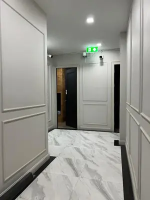 an empty lobby with a door and a sign on the wall at Poshtel 56 in Bangkok
